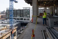 Jobsite photo — tower crane and worker on an elevated deck